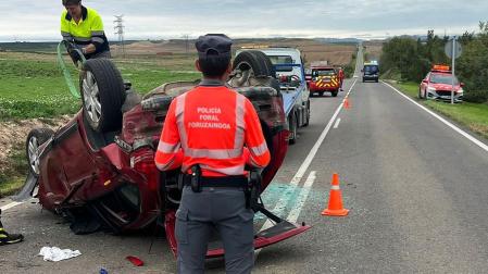 Un agente de la Policía Foral junto al automóvil accidentado en la NA-115 en Peralta