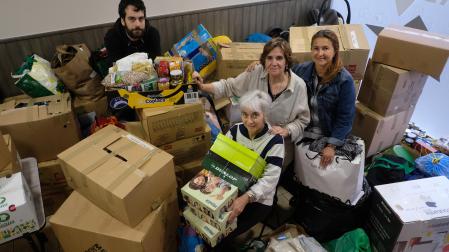 Vilma Silva,  Ana Bello (sentada), su hijo Asier Ortega y Montserrat Port posan con parte de la mercancía donada por los vecinos y vecinas de Zizur Mayor para la asociación Apoyo Mutuo.