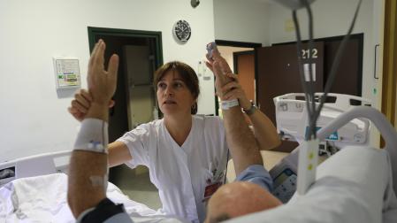 María Herrera Isasi, coordinadora de ictus de Neurología del Hospital Universitario de Navarra, junto a un paciente ingresado en la Unidad de Ictus
