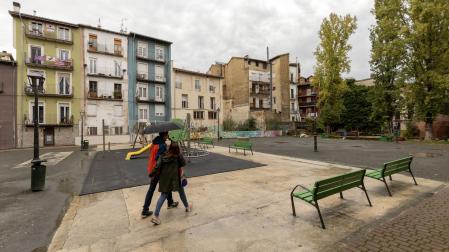 Una pareja atraviesa la plaza de Santa Ana de Pamplona en un día lluvioso