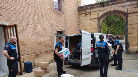 Policías municipales de Estella cargan este lunes el material recogido en la escuela de música antes de emprender viaje a Valencia.