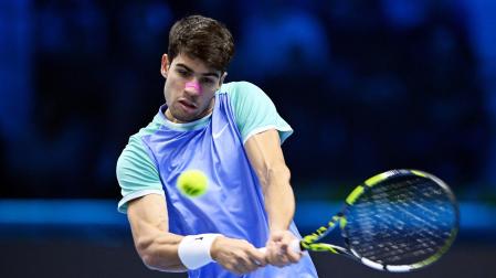 El tenista español Carlos Alcaraz devuelve una bola frente al ruso Andrey Rublev en su partido de las Finales ATP en Turín