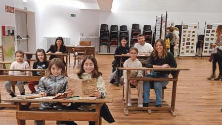Profesoras, ex alumnos y ex alumnas y alumnas actuales del centro en el aula antigua que se recreó