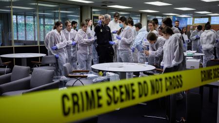 Un agente de la Policía Nacional explica a un grupo de alumnos la dinámica de la investigación
