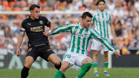 Giovani Lo Celso del Betis lucha por el balón con German Valera del Valencia durante el partido de la jornada 14 de LaLiga disputado este sábado en el estadio de Mestalla