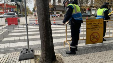 Dos agentes de Policía Municipal colocan cintas para evitar que peatones se cuelen por el paso de cebra anulado en Pío XII