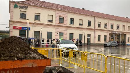 En primer plano, las obras preparatorias de la marquesina. Detrás, pasajeros bajo la lluvia