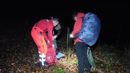 Los excursionistas, tras ser localizados, junto a miembros de los servicios de emergencia