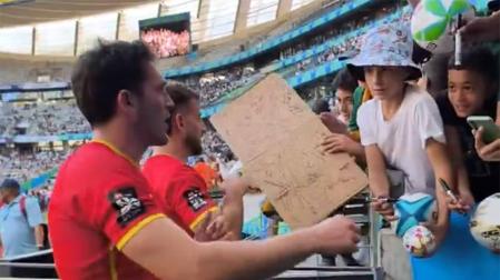 Ángel Bozal, a la izda., atiende a aficionados en el DHL Stadium