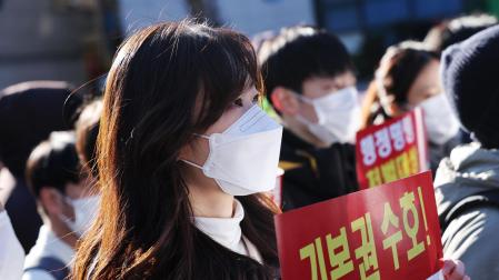 Profesores y médicos en formación del Hospital de la Universidad Nacional de Seúl sostienen pancartas en una manifestación contra la ley marcial en Seúl