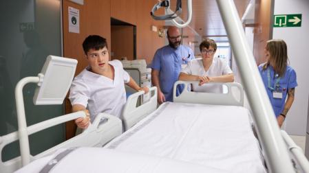 Gorka Rubio, Íñigo Álvarez, Marcos Beriáin y Ana Marrodán, empujando una cama en el Hospital San Juan de Dios de Pamplona.