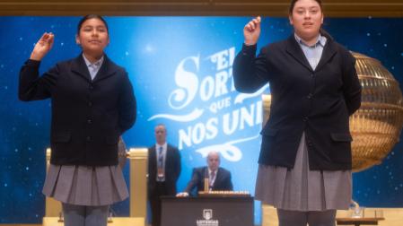 Yadira Quinde Mendoza (i) y Kiara Román Benítez (d), cantan un quinto premio, el número 45.225 durante la celebración del Sorteo Extraordinario de la Lotería de Navidad 2024