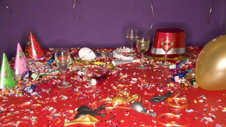 Restos de una fiesta de cotillón. Serpentinas, gorros, confeti y matasuegras, por el suelo
