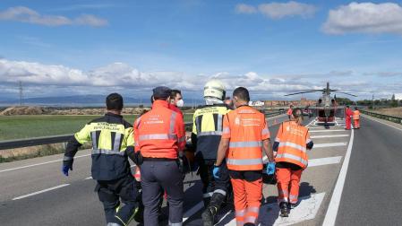 Bomberos, agentes de Policía Foral y sanitarios trasladan a un herido a un helicóptero
