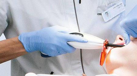 Un dentista trabaja en la boca de un paciente