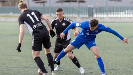 Eneko Oroz, del Valle de Egüés, busca robar el balón ante Elizalde y Oihan Goñi, del Txantrea
