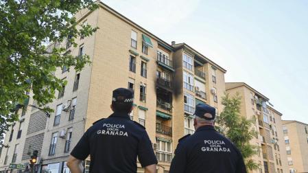 Dos efectivos de la Policía Local de Granada, frente al inmueble en el que se produjo el incendio en mayo de 2023, en la calle Circunvalación del barrio de la Chana, en Granada