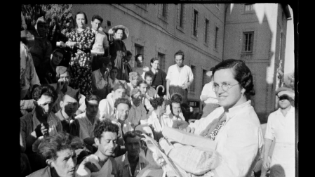 Una ‘margarita’ del Baztan reparte cajetillas de tabaco y dulces entre los heridos sentados en la escalinata de entrada del hospital de sangre de Lekaroz, en septiembre de 1936