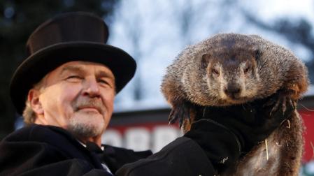 Un miembro del Club de la Marmota sostieniendo a la marmota Phil, el animal meteorólogo más famoso del mundo