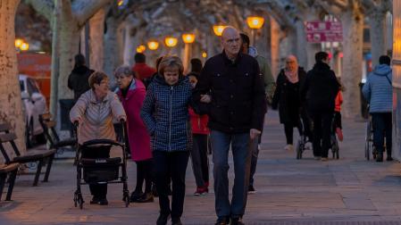 Varias personas pasean por el paseo del Padre Calatayud, en Tafalla /