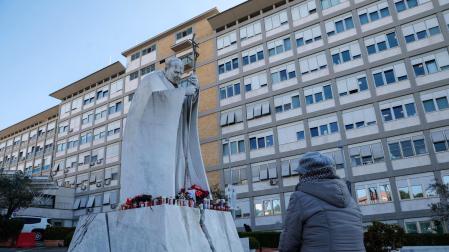 Una persona reza ante el estatua de Juan Pablo II, en el exterior del hospital Gemelli de Roma
