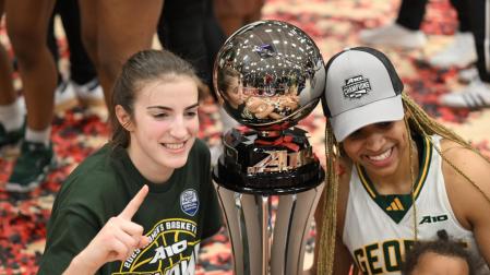 La base navarra Paula Suárez (izda.), junto al trofeo que consiguió con su equipo, el George Mason, como campeón de conferencia