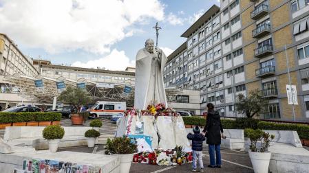 Una mujer y un niño, ante la estatua de Juan Pablo II en el exterior del hospital Gemelli de roma