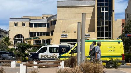 Dos hombres pasan delante del hospital donde han sido transportados los cuerpos de los seis turistas extranjeros fallecidos en el accidente del submarino, en Hurgada este jueves.