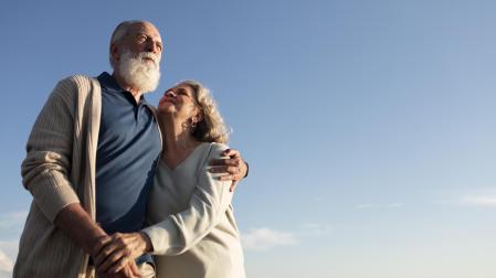 Una pareja de adultos mayores abrazándos.