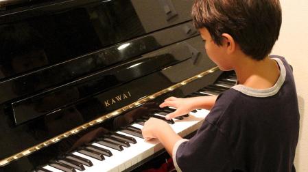Un niño aprendiendo a tocar el piano