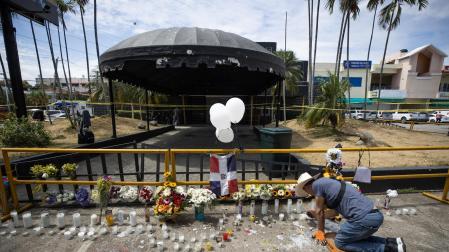 Un hombre enciende velas en la entrada de la discoteca Jet Set, en Santo Domingo (República Dominicana)