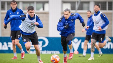 Bryan Zaragoza pelea un balón con Iker Muñoz en el entrenamiento bajo la lluvia celebrado este sábado