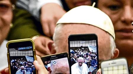 Un grupo de personas toma fotos del Papa Francisco, en una de sus apariciones públicas.