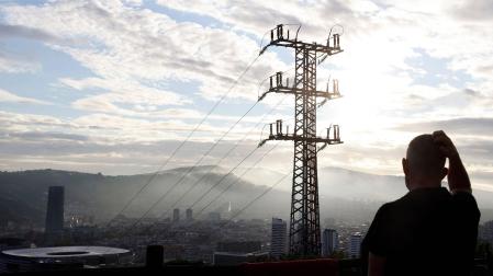 Una persona observa el cableado con el que Red Eléctrica transporta la energía sobre la ciudad de Bilbao