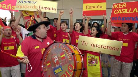 Un grupo de aficionados surcoreanos ataviados con camisetas rojas y banderas de Espa¿a, acompa¿ados del aficionado m¿s fiel de la selecci¿n espa¿ola, "Manolo el del bombo", animan a la selección española a su llegada al aeropuerto de Gwuangju