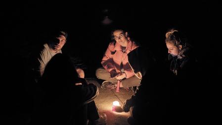 Un grupo de peregrinos se alumbra con una vela en la plaza del Obradoiro de Santiago de Compostela