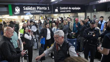 Una trabajadora con un megáfono en la estación de Atocha-Almudena Grandes, tras los retrasos en los trenes AVE