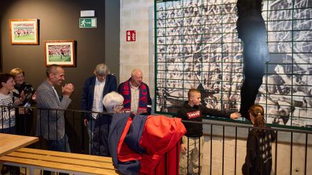 Oihan y Nikole, los hijos de Puñal, junto a la valla de El Sadar que subía Chiquiín y que fue ayer descubierta en  el Txoko de El Sadar, donde va a quedar expuesta. La silueta es la de Enrique Martín, que también aparece en la imagen junto a las tres hijas de Chiquilín, a la izquierda.
