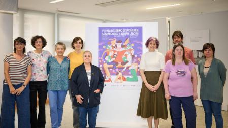 EL CARTEL DE ESTE AÑO, DE ADAM KOZINSKI. Un abuelo, una niña, un joven, un perro, un gato, un pájaro... todos alrededor de un libro o con un libro entre las manos. El autor del cartel, el pamplonés Adam Kozinski, de 32 años, ha elegido una escena cotidiana para representar que podría tener lugar un día cualquiera en esta feria “familiar y cercana” que se organiza en la Plaza del Castillo. Y al poner a leer a los animales lanza con una hipérbole el mensaje de que “la lectura está disponible para todo el mundo y hay un libro para todos y para todas”. Kozinski se fotografió ayer en la presentación junto a, desde la izquierda, Clara Flamarique (Servicio de Biliotecas), Nerea Reta (Nerea), Loles Ursúa (Troa),  Giorgia Saiu (Arcos), Asun Maestro (directora del Servicio de Bibliotecas), Rebeca Esnaola (consejera de Cultura), Itziar Olabe (Muga) y Maider Díaz (Chundarata)