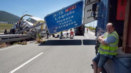 En primer plano, el camionero que casi choca con la señal de la autopista