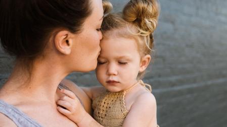 Una niña en brazos de su madre