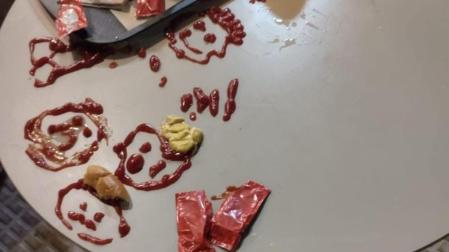 La mesa, manchada con pintadas realizadas con ketchup