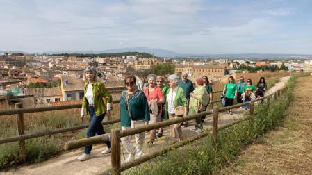 Varios de los voluntarios participantes en la iniciativa 'Memorias del Castillo' pasean por la senda acotada en una de las laderas del Cerro de Santa Bárbara de Tudela