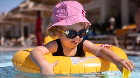 Una niña con gafas de sol en la piscina
