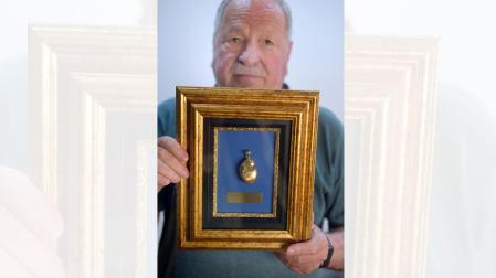 José Ochoa muestra el Haba de Oro que ANAS recibió por el trabajo de la asociación