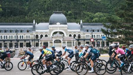 Ciclistas de la Quebrantahuesos pasan ante la antigua estación de tren de Canfrac