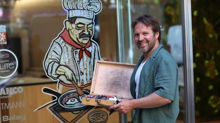 Iosu Zapata este jueves con el cocinero que ha dibujado en una tienda de cocinas