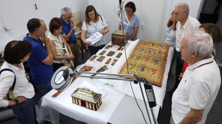 Al fondo, con folios en la mano, Alicia Ancho Villanueva explica los trabajos de restauración de piezas artísticas en el Almacén de Arqueología de Navarra