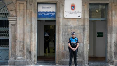 Un agente de la Policía Municipal de Pamplona posa junto a la nueva oficina de denuncias para San Fermín