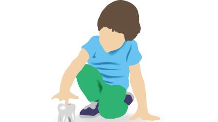 Imagen de un niño jugando con la prótesis de una muela 7